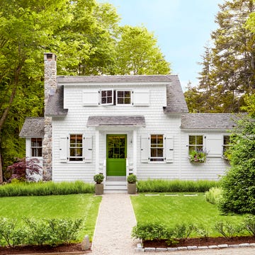 white shingled cottage with bright green door