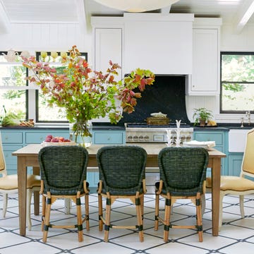 kitchen with blue lower cabinets, large windows and a table with eight chairs